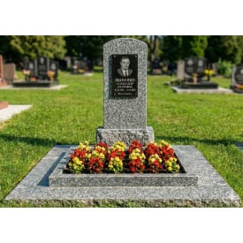 Памятник с большим цветником и отмосткой серый гранит.